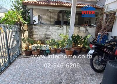 front yard of a residential house with parked motorcycle and potted plants
