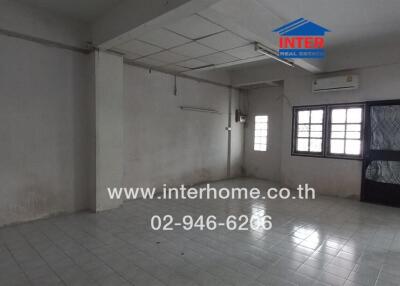 Spacious empty living area with tiled floor and large windows