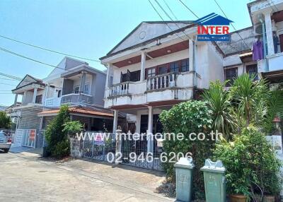 Two-story residential building with a balcony and ample parking