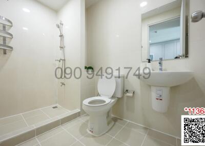 Modern bathroom with white fixtures, including a walk-in shower, wall-mounted sink, and toilet