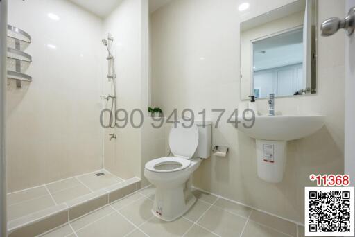 Modern bathroom with white fixtures, including a walk-in shower, wall-mounted sink, and toilet