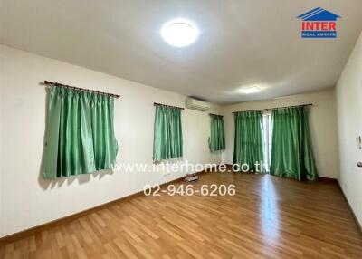 Spacious bedroom with large windows and green curtains
