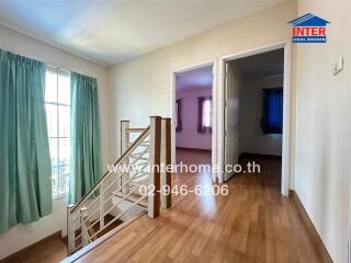 Spacious living room with wooden floors and staircase leading to another floor