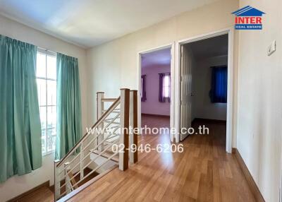 Spacious living room with wooden floors and staircase leading to another floor