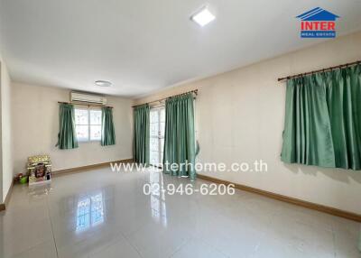 Spacious and bright living room with large windows and tiled flooring