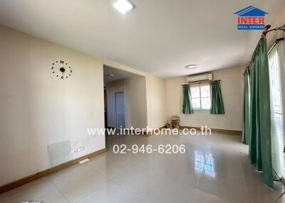 Spacious and bright living room with large windows and tiled flooring