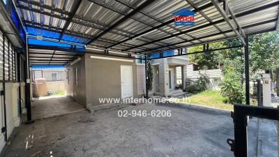 Spacious garage with sheltered roofing and adjacent auxiliary building