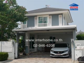 Modern two-story house with carport and lush landscaping