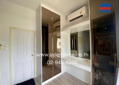Modern bedroom with large mirror wardrobe and air conditioning