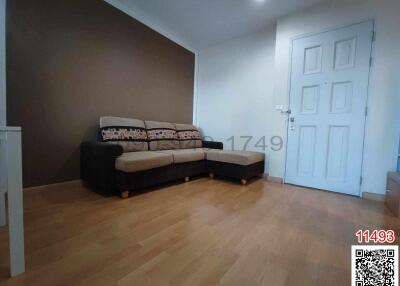 Spacious living room with modern brown sofa and hardwood flooring