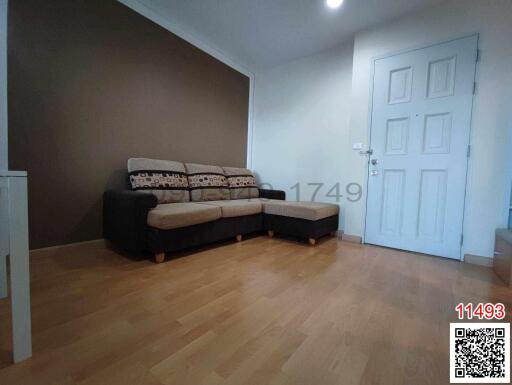 Spacious living room with modern brown sofa and hardwood flooring