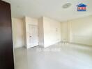 Spacious and bright living room with white walls and glossy floor tiles