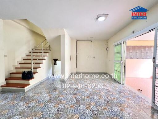 Spacious living room with staircase and tiled flooring