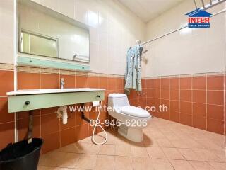 Spacious bathroom with white tiles and basic fixtures
