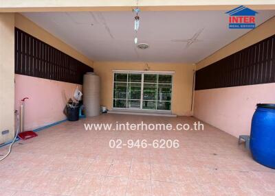 Spacious covered patio area with large windows and tiled flooring