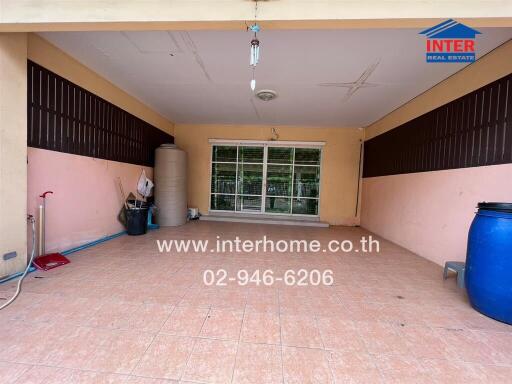 Spacious covered patio area with large windows and tiled flooring