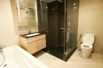 Modern bathroom with bathtub, walk-in shower, and wooden vanity