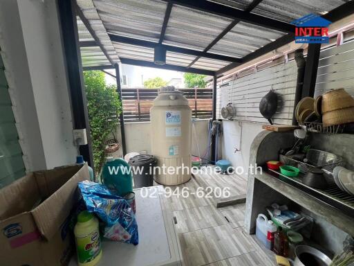 Messy outdoor kitchen area with appliances and household items