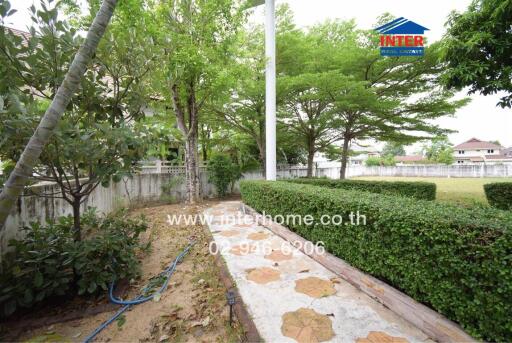Spacious outdoor area with green lawn and paved pathway