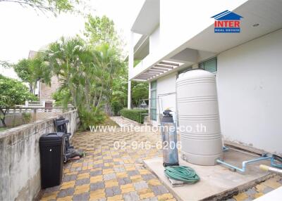 Exterior view of a house showing water tank and garden hose