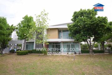 Modern two-story house with large windows and landscaped front yard