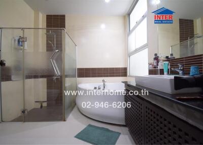 Spacious modern bathroom with bathtub and glass shower