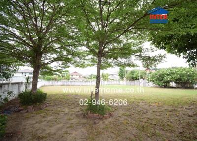 Spacious backyard with mature trees and fenced perimeter