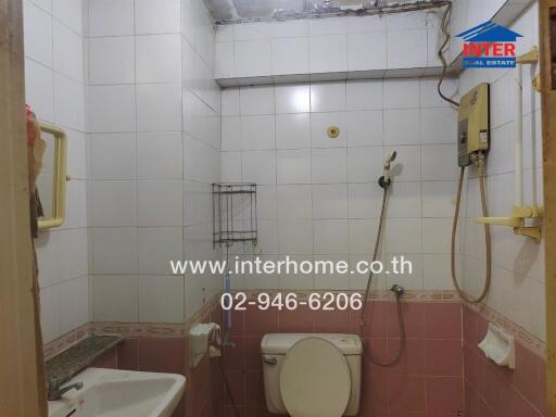 Compact bathroom with tiled walls and visible wear