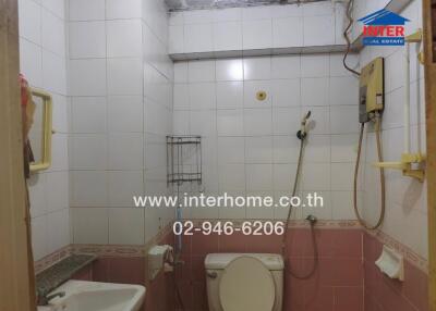 Compact bathroom with tiled walls and visible wear