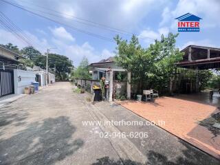 Paved residential area with trees and a clear sky