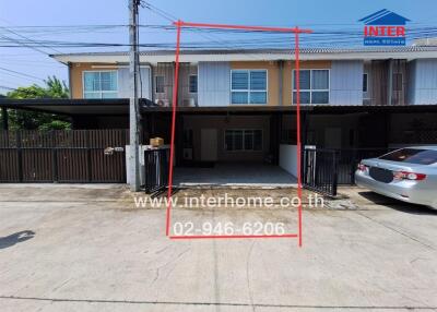 Front view of a modern townhouse with parked cars and clear sky