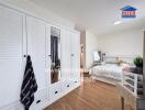 Spacious bedroom with large white closet and cozy bedding