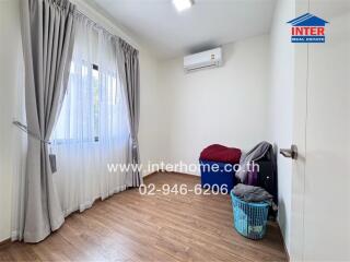 Spacious and well-lit bedroom with large windows and air conditioning