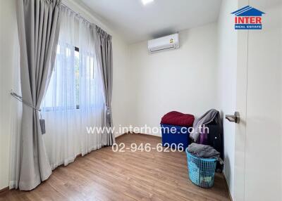 Spacious and well-lit bedroom with large windows and air conditioning