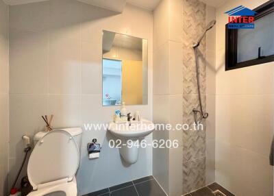 Modern bathroom with white tiles, shower area, and clean design