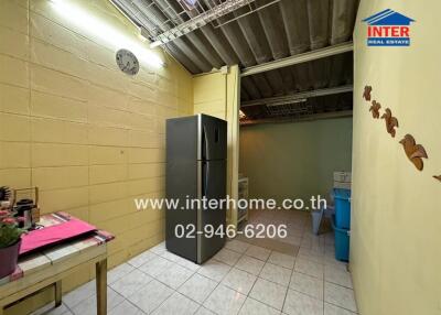 Compact kitchen area with refrigerator and basic amenities