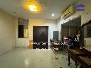 Empty indoor space with basic appliances and a wooden table