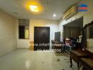 Empty indoor space with basic appliances and a wooden table