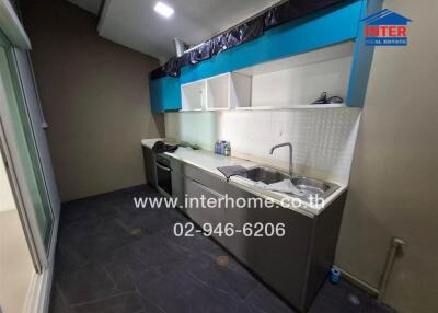 Modern compact kitchen with ample storage and black tiled flooring