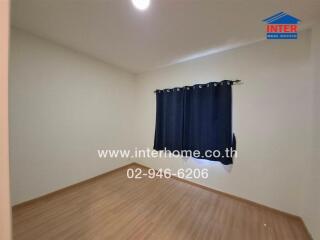 Empty bedroom with wooden flooring and a single window