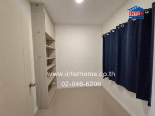 Modern bedroom with built-in shelving and dark blue curtains