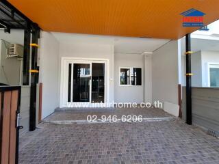 Covered patio area of a modern home with tiled flooring and bright orange ceiling