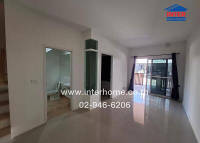 Spacious living room with large windows and access to balcony
