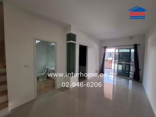 Spacious living room with large windows and access to balcony