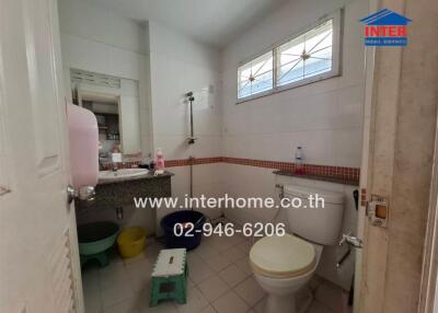 Spacious bathroom with large window and essential amenities