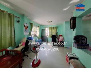 Spacious and brightly lit living room with green walls and multiple seating options