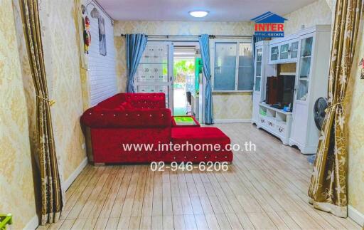 Bright and cozy living room with red sofa and access to balcony