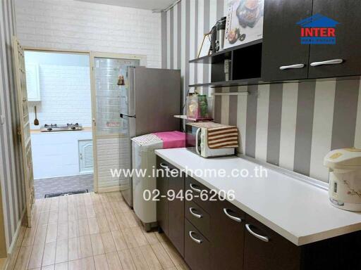 Compact and modern kitchen with appliances and striped wallpaper