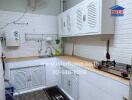 Modern kitchen with white cabinets and wooden countertops in a well-lit room