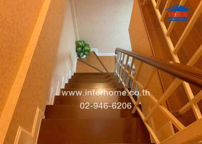 Interior view of a residential staircase with wooden steps and cozy decor